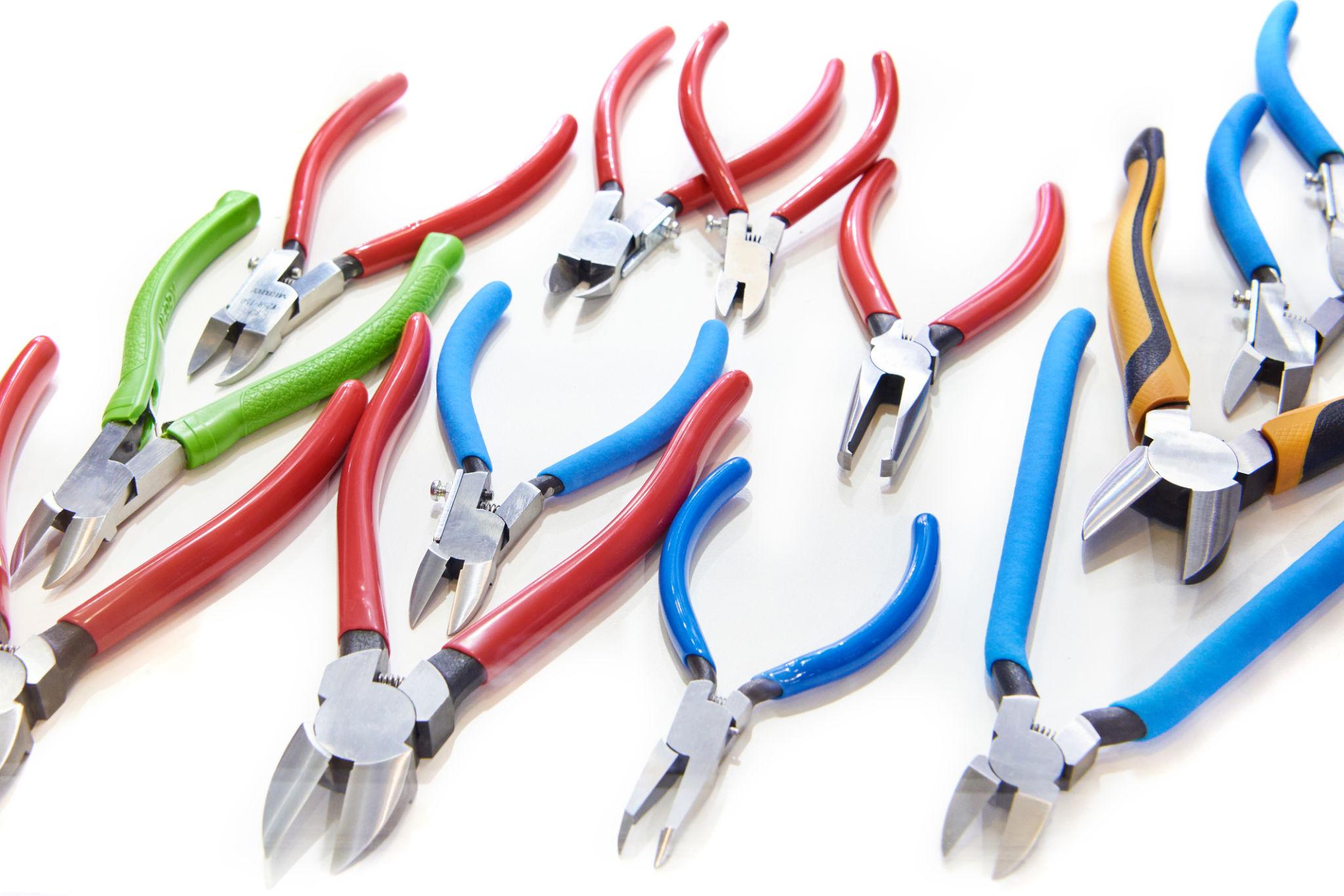 Professional mechanic pliers and cutting tools — needle-nose, locking, snap-ring, hose clamp pliers and wire cutters on a dark foam tool tray