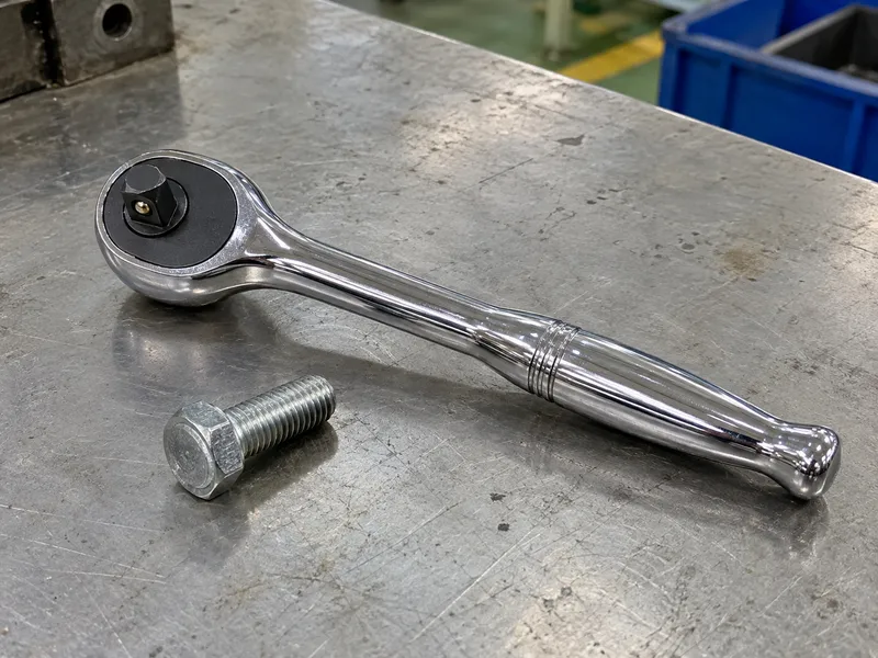Fixed-head ratchet resting beside a hex fastener